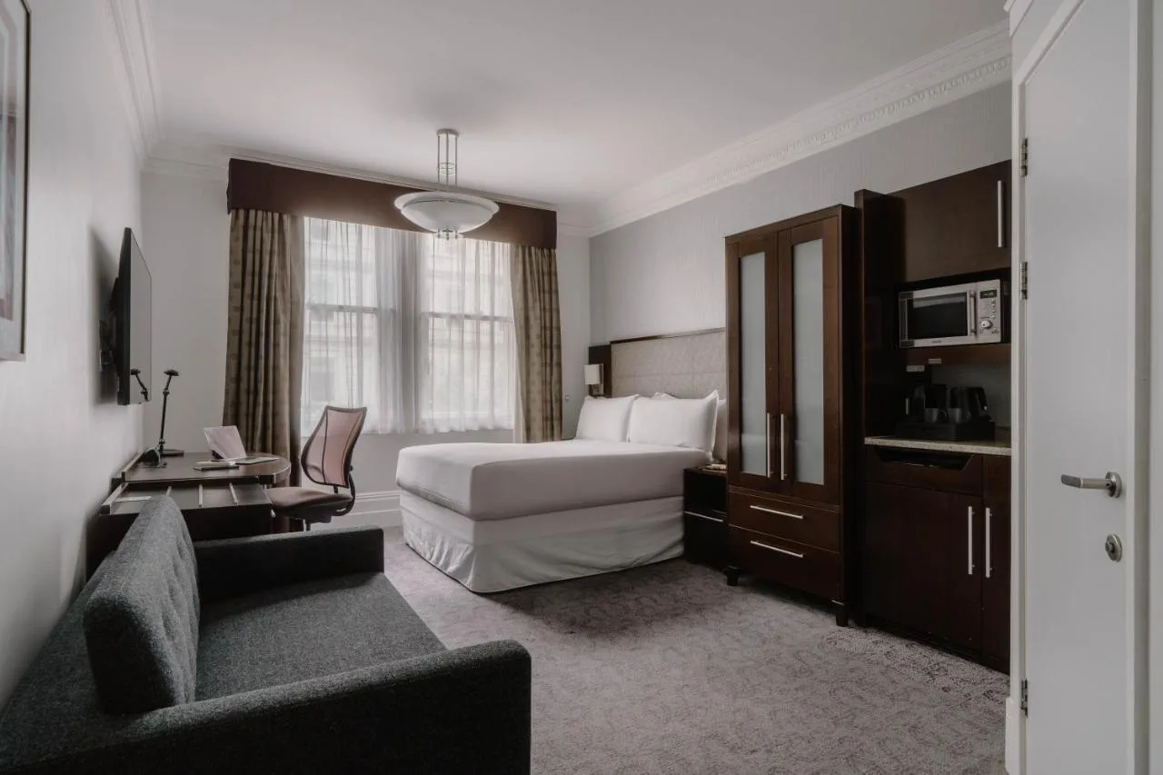 a hotel room with a bed and a couch at Club Quarters Hotel Trafalgar Square, London in London