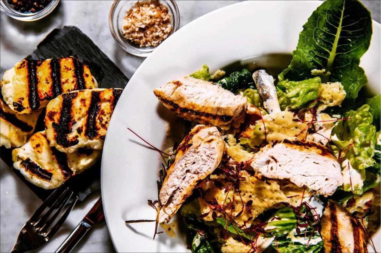 a white plate of food with a salad and meat at Club Quarters Hotel Trafalgar Square, London in London
